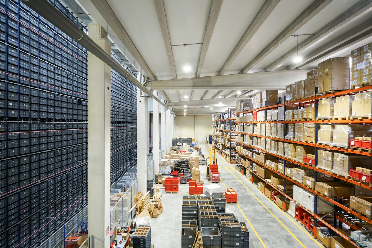 Un vasto almacén industrial con estanterías llenas de contenedores y cajas.